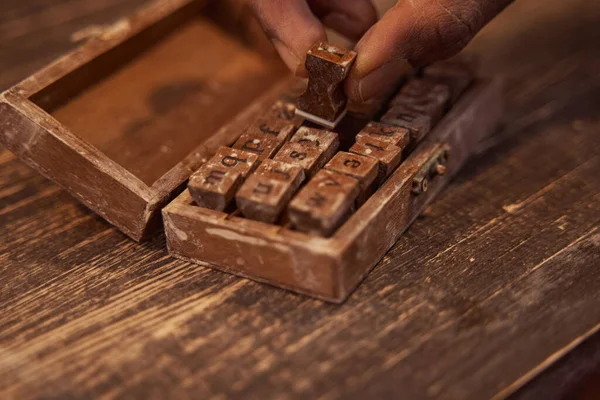 Ceramista profesional seleccionando letras minúsculas para gofrado de arcilla — Foto de Stock