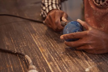 Deneyimli çömlekçi seramik vazonun altını öğütüyor