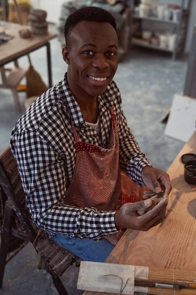 Çamurla çalışan neşeli genç erkek çömlekçi — Stok fotoğraf