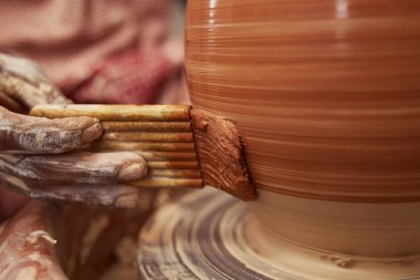 Kalifiye seramistim, toprak kaplamalı kap boyuyor.