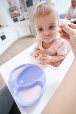 Odada küçük bir çocuğu besleyen tanınmamış bir kadın.