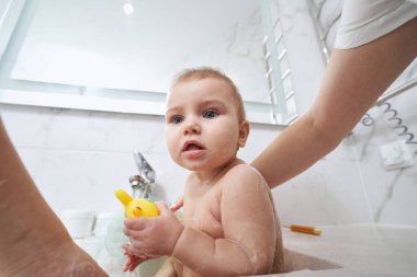 Banyo lavabosundaki sevimli bebek içeride hijyen prosedürü uyguluyor.