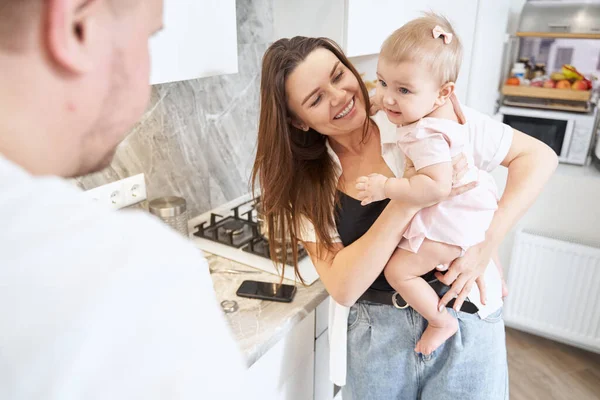 Küçük çocuğu evde gülümseyen genç, beyaz bir anne.