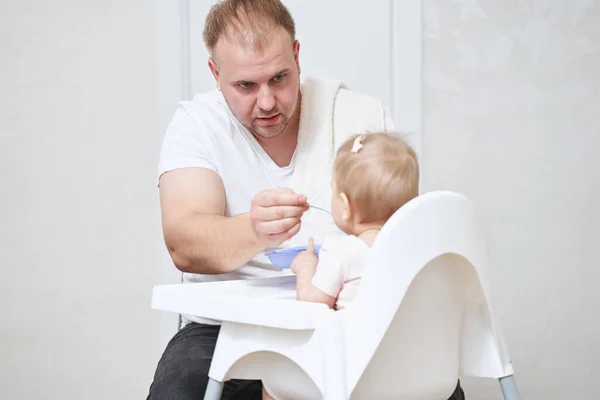 Papà con stoppie in abiti bianchi trascorrere del tempo con la figlia durante la colazione a casa — Foto Stock