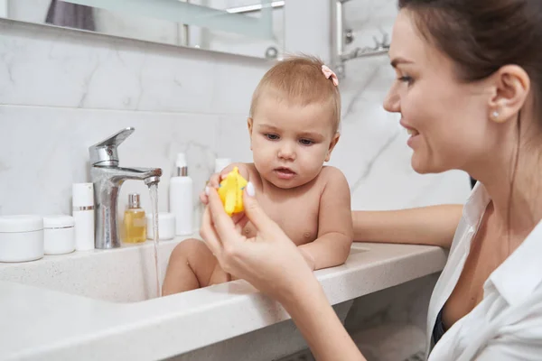 Baby dívka s maminkou dělá hygienický zákrok v koupelně — Stock fotografie