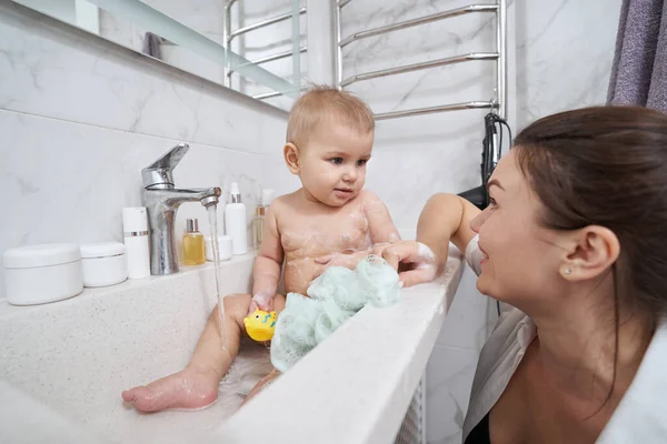 Dítě v koupelně umyvadlo mytí ve vodě z ventilu — Stock fotografie