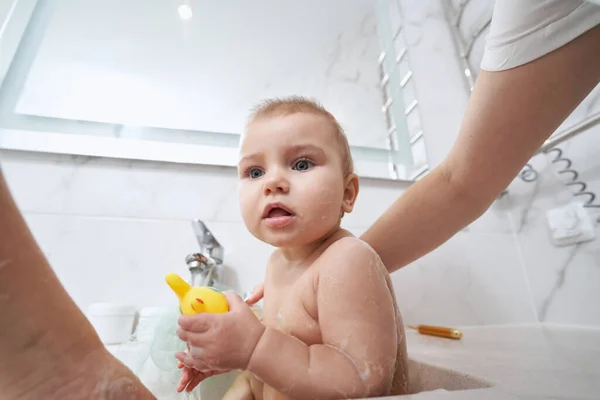 Cute baby in bathroom sink having hygiene procedure in room indoors — Stock Photo, Image