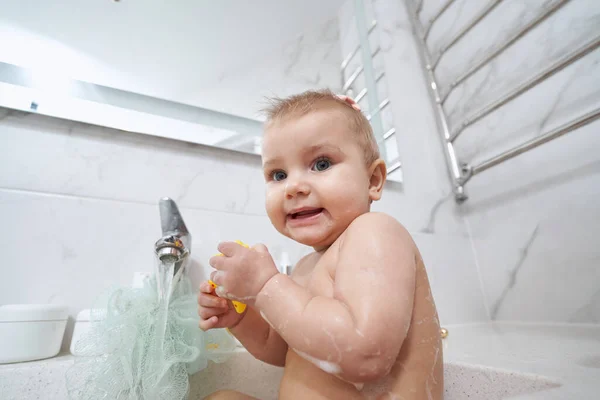Scared baby staring at camera while taking bath — Stock Photo, Image