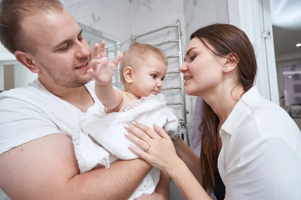 Doting mère regardant bébé dans les mains du père — Photo