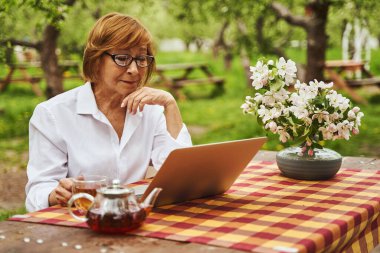 Bahar bahçesinde çalışan mutlu bir kadın.
