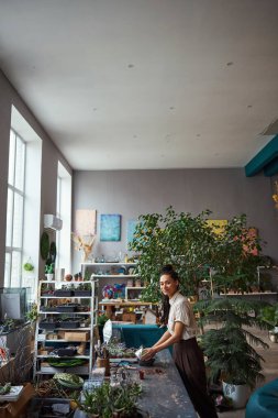 Profesyonel sükunet çiçeği dekoratörü sulu bir çiçek dikiyor.