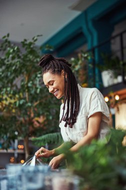 Çiçekçi bir çiçekçiyle ilgileniyor.