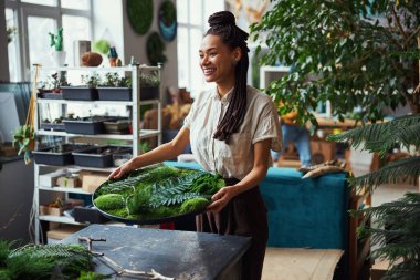 Yosun sanat eserleri olan mutlu bir çiçekçi.