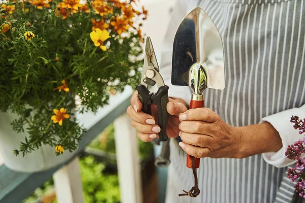 Señora madura con instrumentos de jardín en la terraza — Foto de Stock