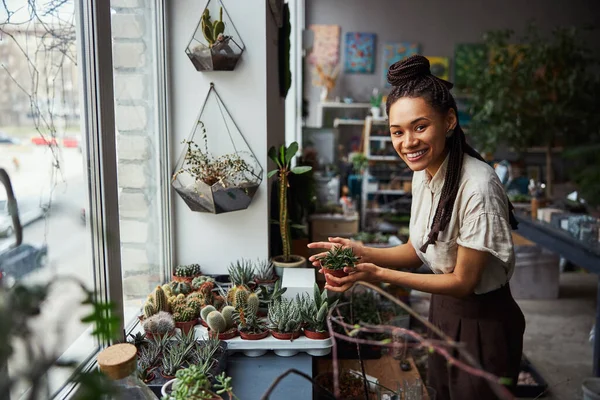 Cheerful florist posing for the camera with a potted plant — Stock Photo, Image