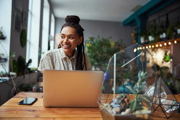 Sonriente diseñador floral de pelo oscuro soñando despierto en el trabajo —  Fotos de Stock