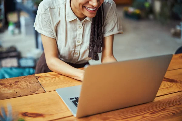Весела молода леді з крупами, що працюють на її ноутбуці — стокове фото