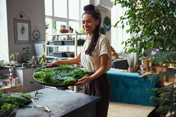 Smiling joyous floral decorator demonstrating her moss art piece — Stock Photo, Image