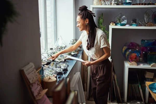 Merry professional florist touching a polyhedron florarium — Stock Photo, Image