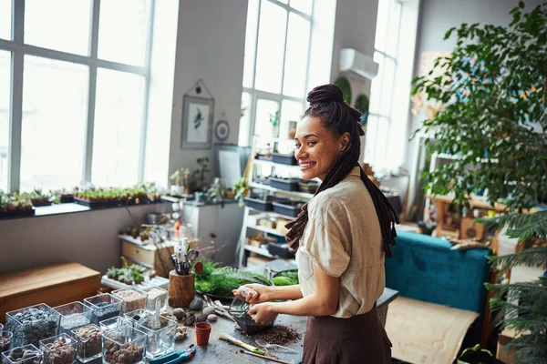 Pleased florist using natural stones for a florarium decoration — Stock Photo, Image