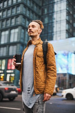Şehir merkezinde kahve içen yakışıklı hippi.