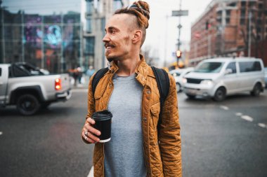 Neşeli genç erkek, şehirde eğleniyor.