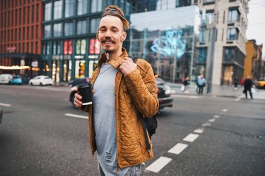 Neşe dolu genç adam şehir merkezinde karşıdan karşıya geçiyor.