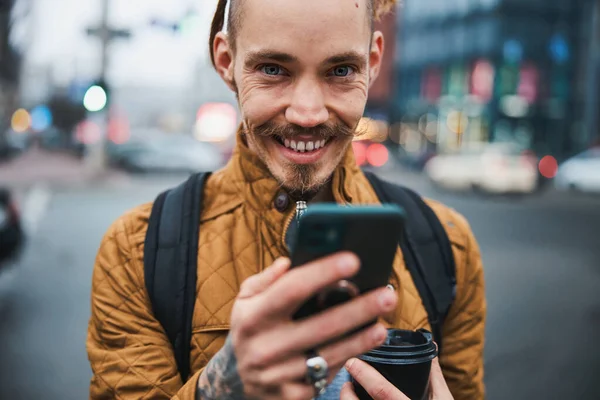 Veselý chlap zprávy na smartphone v městské ulici — Stock fotografie