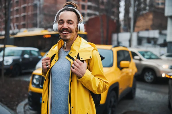 Veselý vousatý muž těší hudbu ve sluchátkách venku — Stock fotografie