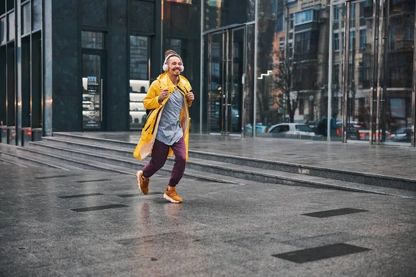 Veselý mladý muž běží po městské ulici — Stock fotografie