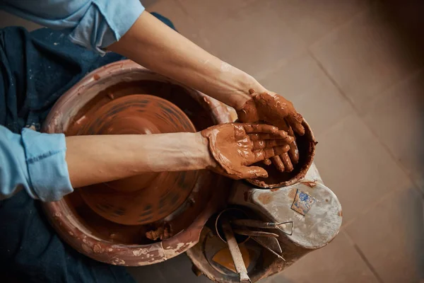 Mujer artesanal que trabaja en taller de cerámica mientras hace vajilla de cerámica —  Fotos de Stock