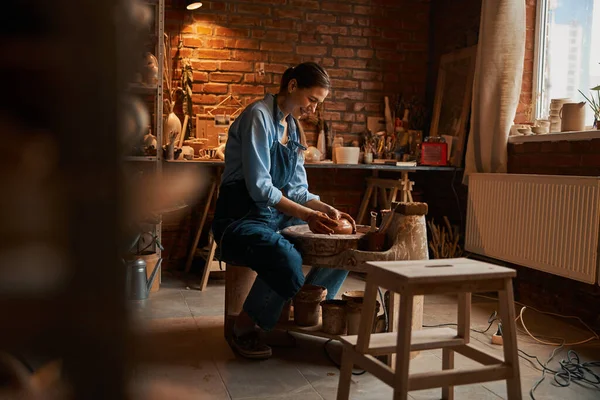 Hermosa joven artesana caucásica trabajando con arcilla húmeda fresca en taller de cerámica —  Fotos de Stock