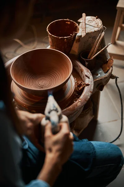 Artesana femenina no reconocida trabajando en la rueda de cerámica mientras hace cuenco de cerámica en el estudio de arte —  Fotos de Stock