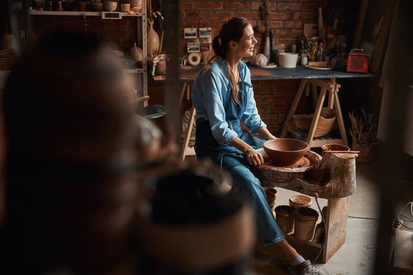 Hermosa mujer artesana elegante descansando durante el delicado proceso de fabricación de vajilla de cerámica en taller de cerámica —  Fotos de Stock