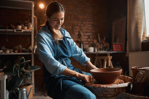 Кавказький керамік Брюнет працює з свіжою глиною, виготовляючи чашу в гончарній майстерні. — стокове фото