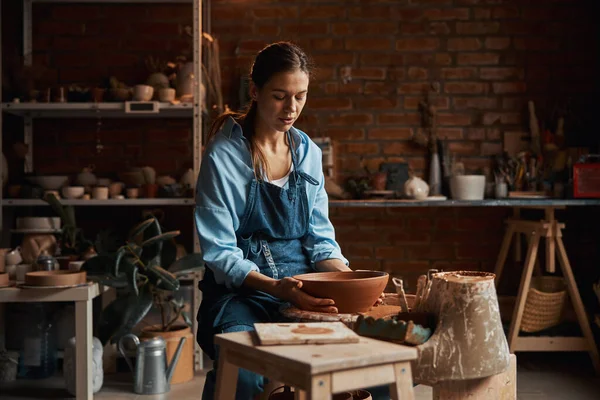 Красивая молодая кавказская ремесленница делает посуду в художественной уютной студии — стоковое фото