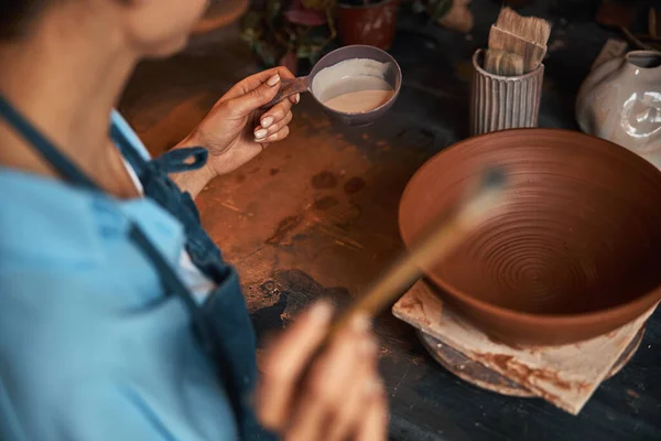 Obraz procesu malowania ceramicznych zastaw stołowych przez ceramika w warsztacie garncarskim — Zdjęcie stockowe