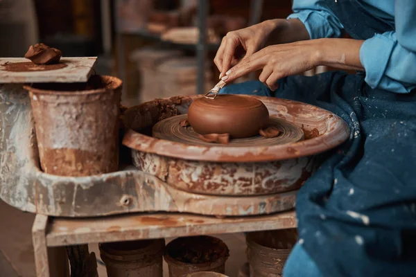 Mulher artesanal não reconhecida sentada ao lado da roda de cerâmica em boutique de arte — Fotografia de Stock