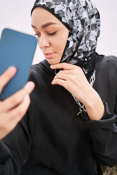 Tânără femeie în hijab luând selfie în interior — Fotografie, imagine de stoc