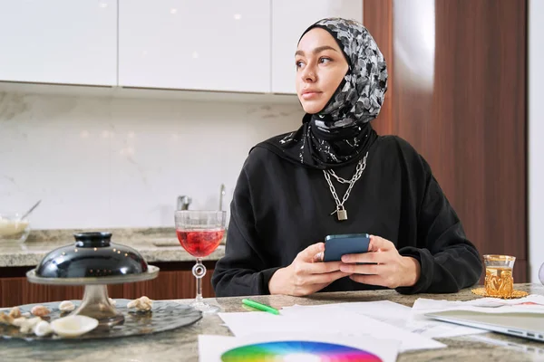 Relaxed muslim young woman surfing internet in kitchen — Stock Photo, Image