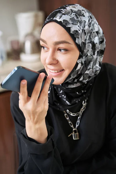 Vrolijke moslim vrouw spreekt op smartphone thuis — Stockfoto