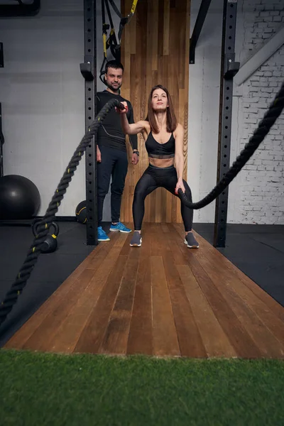 Mujer deportiva usando cuerdas de fitness en el gimnasio — Foto de Stock