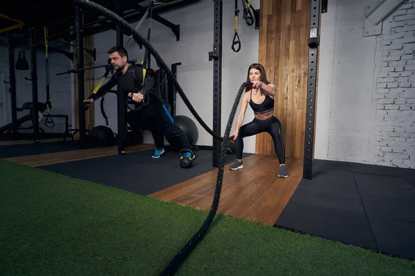 Erkek ve kadın spor salonunda idman yapıyor.