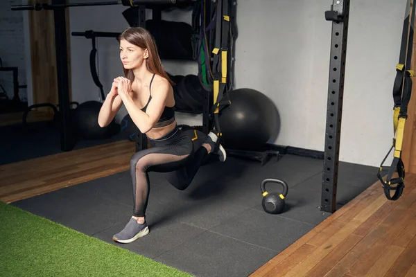 Mujer atlética haciendo ejercicios de embestidas en el gimnasio — Foto de Stock