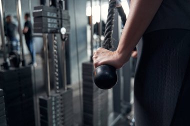 Spor salonunda spor aletleri kullanan kadın eli.