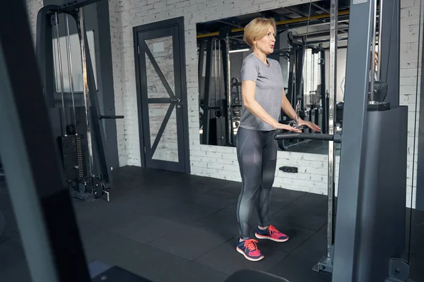 Mujer deportiva que utiliza entrenador de gimnasio durante el entrenamiento de fuerza — Foto de Stock