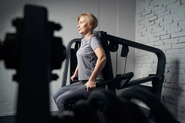 Mujer deportiva usando entrenador de gimnasio en el gimnasio — Foto de Stock