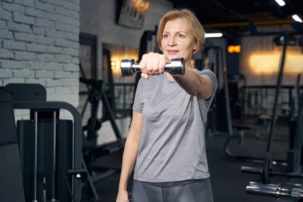 Mujer haciendo ejercicio con mancuerna en el gimnasio — Foto de Stock