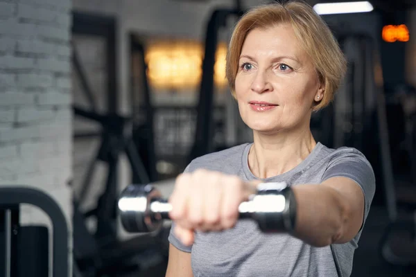 Kvinna som tränar med hantel i fitnesscenter — Stockfoto