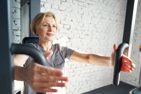 Lächelnde Frau mit Fitnessgeräten im Fitnessstudio — Stockfoto